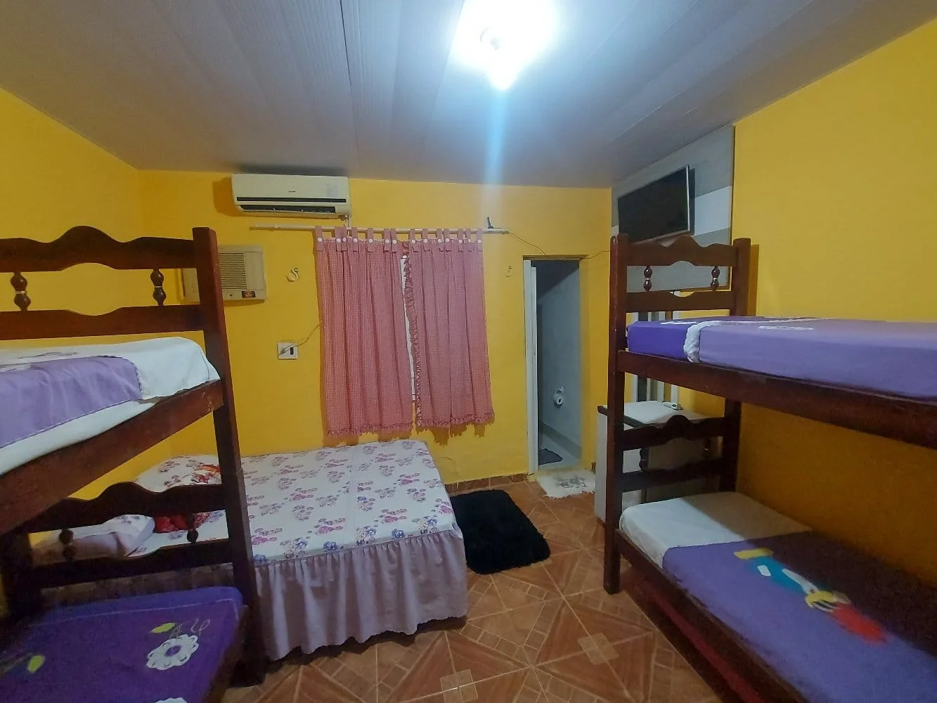 Quarto com cama, TV, ar-condicionado e frigobar